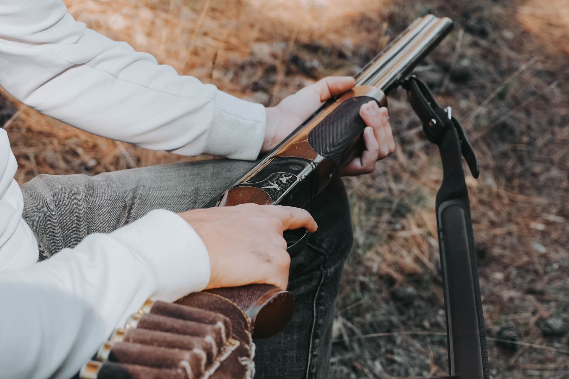 A shooter loading a shotgun outdoors